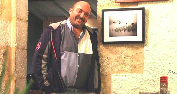 Eljo devant sa photographie pour l'exposition "Entre ciel et terre" au restaurant de Mauvezin La Grande Ourse en 2016.
