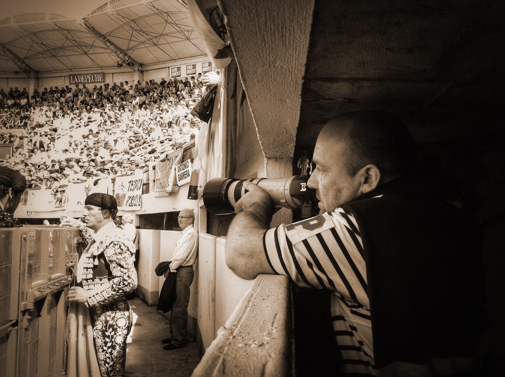 Photographie montrant l'artiste Eljo en position pour capturer des moments intense d'une corrida.